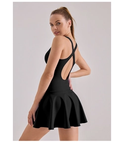Detail of cross-back X-straps and pleated hem on a black high-elastic athletic dress