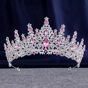Macro shot of silver bridal crown featuring pink teardrop crystals on navy background