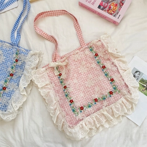 Detail of floral embroidery and ruffled lace edges on a large canvas tote bag
