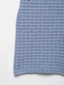 Macro view showing light blue waffle knit texture and fabric detail of the dress