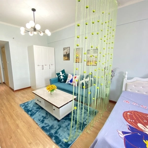 Detail of light green string curtain divider with decorative silver beads in a home setting