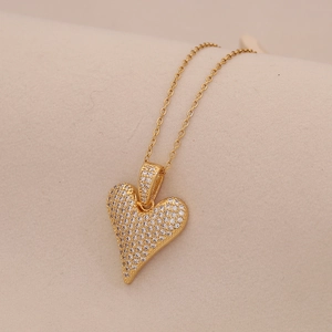 Macro shot of gold heart pendant with micro-set zircon stones on a delicate chain