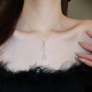 Détail du collier avec pendentif gourde plaqué or, zircons brillants et gemme blanche