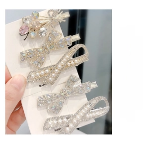 Detailed macro view of five luxury hair clips with pink crystals and pearls on gold base