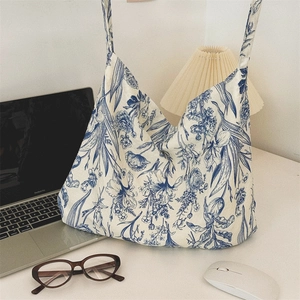 Retro blue floral cotton tote bag styled with a laptop and lamp in a cozy office scene