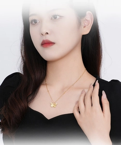 Close-up of golden butterfly pendant necklace worn as a delicate clavicle chain