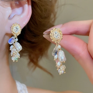 Detail von Vintage Quastenohrringen mit Perlen und Kristallen am Ohr des Models
