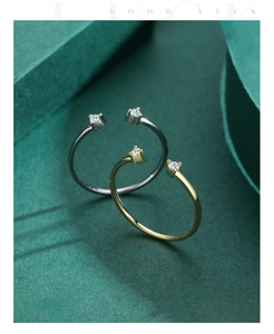 Detail of two minimalist open rings with sparkling round-cut stones in gold and silver finish