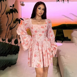 Vue détaillée d'une robe rose à fleurs avec encolure carrée et manches bouffantes