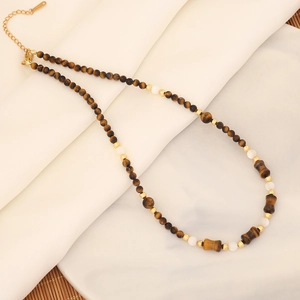 Detalle de collar de perlas de ojo de tigre con detalles dorados finos