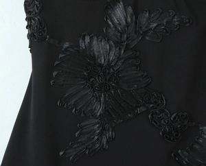 Dettaglio del ricamo floreale 3D nero e texture sull'elegante abito aderente