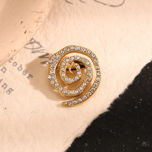 Elegant 18K gold plated spiral brooch with white crystals on a vintage paper background