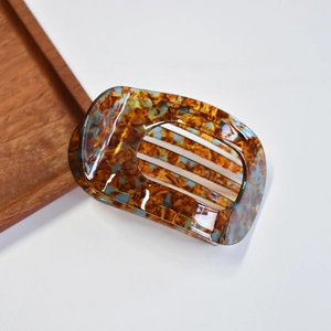 Detail of tortoise shell acetate hair claw clip with vintage amber pattern and hollow design