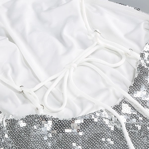 Close-up of silver sequin evening dress showing back criss-cross straps and shimmering texture
