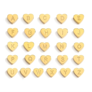 Makroaufnahme goldener Herzanhänger aus Edelstahl mit gravierten A-Z Alphabet-Buchstaben