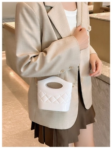 Dettaglio della mini borsa trapuntata bianca con catena in metallo dorato e manico