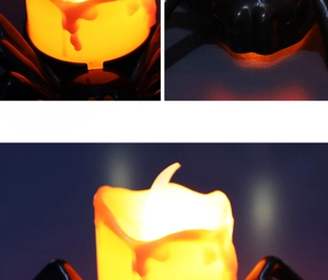 Close-up of LED Halloween candle light with warm orange glow and black spider base