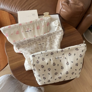 Three-piece floral cotton makeup bags with simple wish labels on a vintage wood table