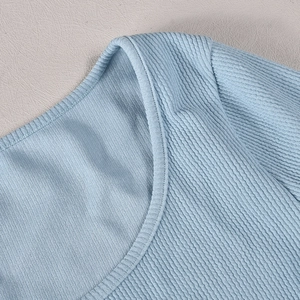 Detailed close-up of light blue ribbed knit fabric neckline and stitching quality