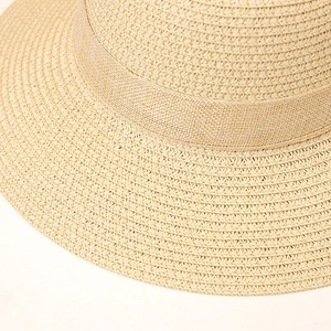 Close-up of fine cross-weave texture and ribbon detail on natural straw sun hat