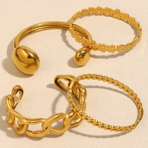 Détail de quatre bracelets en acier inoxydable plaqué or 18 carats avec motifs de fleurs