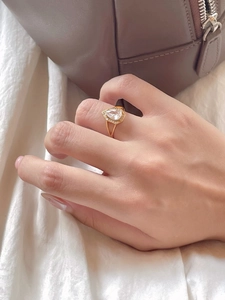Detailed view of an elegant gold pear-cut crystal ring with micro-pave diamonds on model hand