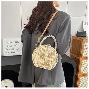 Beige woven straw shoulder bag with elegant pearl handle and floral accents