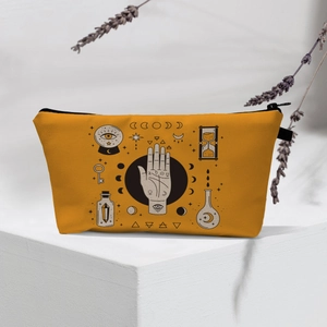 Detailed close-up of orange canvas makeup bag with mystical celestial and magic patterns