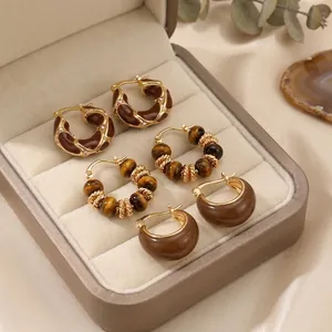 Retro tiger eye earring set with golden metal and brown enamel finish displayed on satin