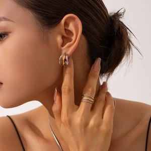 Macro shot of minimalist gold and silver intertwined dual-tone metal rings on model