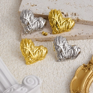Artistic gold and silver heart-shaped earrings with fluid textured metal design