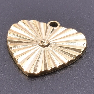 Macro shot of 18k gold plated heart pendant with radial sunburst texture and polished finish