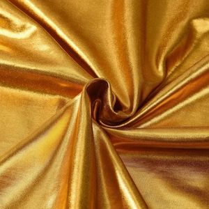 Dettaglio del tessuto in seta di ghiaccio dorata con riflessi metallici e drappeggio