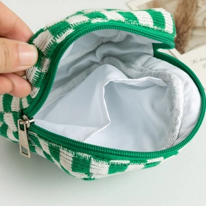 Macro shot of green and white checkered knit pouch showing inner pocket and lining
