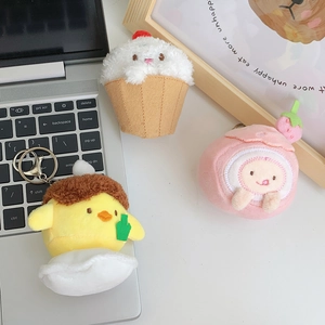 Detailed view of plush strawberry cream and cheese dessert charms on a desk