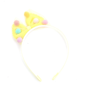 Kids yellow tulle bow headband with colorful fuzzy pom-poms on white background