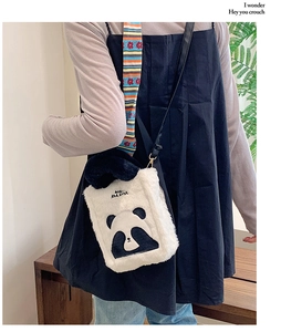 Detail view of a cute panda plush crossbody bag with soft black and white fur texture