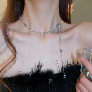 Detail of silver floral Y-necklace with crystal droplets on an elegant model
