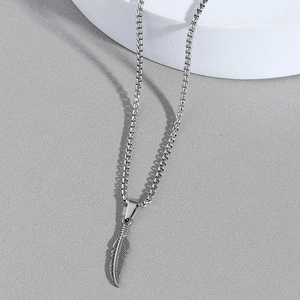 Silver stainless steel feather pendant necklace with box chain on a minimalist display