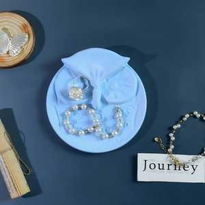 Moule en silicone en forme de hibou avec bijoux en perles sur fond sombre