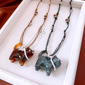 Detailed close-up of resin cat necklaces with pearl collars and flower accents