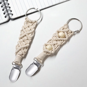 Close-up of beige hand-woven cotton hat clips with metal rings and wooden beads