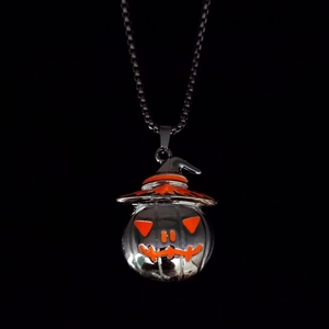 Macro shot of Halloween pumpkin wizard pendant with orange accents and steel chain