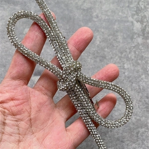 Detailed view of an oversized silver hair clip with sparkling rhinestones in bow shape