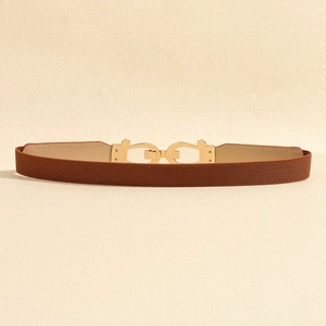 Detail of dark brown elastic belt featuring a golden interlocking metallic buckle