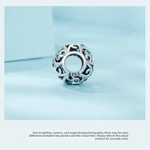 Close-up of S925 sterling silver hollow scroll charm with sparkling blue zircon stones
