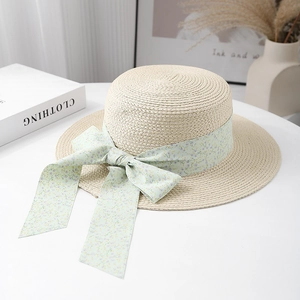 Straw sun hat with green floral bow ribbon in elegant cream white for beach vacations