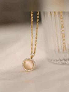 Detail of golden rotating necklace with cat eye stone and pavé cubic zirconia halo