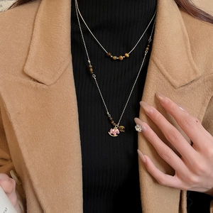 Détail du collier double couche en acier inoxydable avec perles oeil de tigre et pendentif