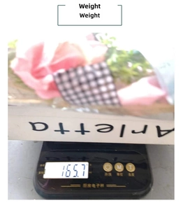 Detail shot of artificial pink rose bouquet on scales showing a weight of 165.7 grams